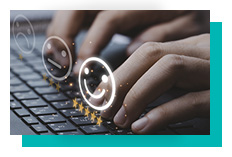 Close-up of hands on a keyboard taking a survey with smiley face options