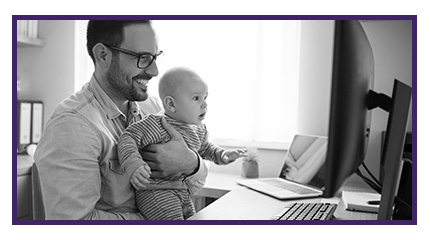 Man with baby on his lap looking at a computer