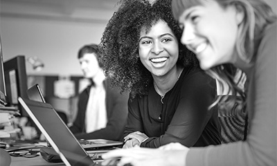 GenZ woman wearing a hat and using a tablet