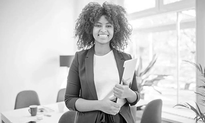 Woman smiling and holding paperwork.