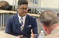 A man in a suit talking to another man.