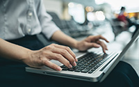 Focus on womans hands using a laptop