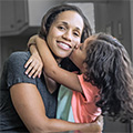 Young daughter kissing her mother on the cheek